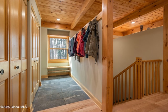 hallway with beamed ceiling, an upstairs landing, baseboards, and wooden ceiling