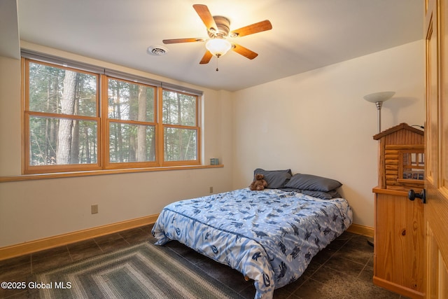 bedroom featuring dark tile patterned floors, baseboards, visible vents, and ceiling fan