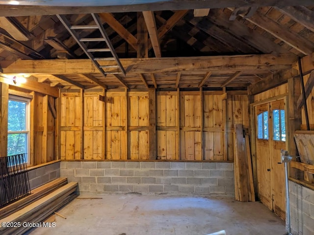 miscellaneous room with concrete block wall and concrete floors