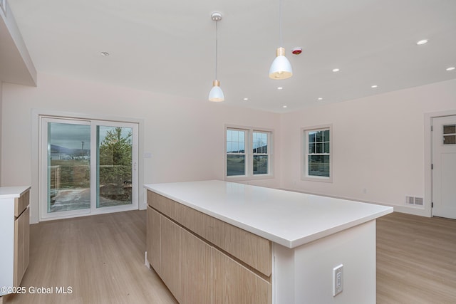 kitchen featuring visible vents, modern cabinets, light brown cabinetry, and light wood finished floors