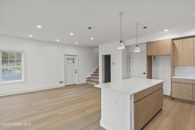 kitchen featuring recessed lighting, light wood-style flooring, a center island, and light countertops