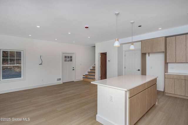 kitchen featuring modern cabinets, light countertops, light wood-style floors, and a kitchen island