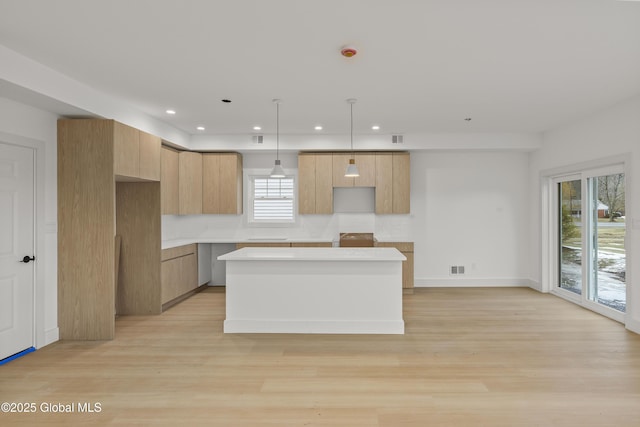 kitchen with a kitchen island, light wood-type flooring, light countertops, recessed lighting, and modern cabinets