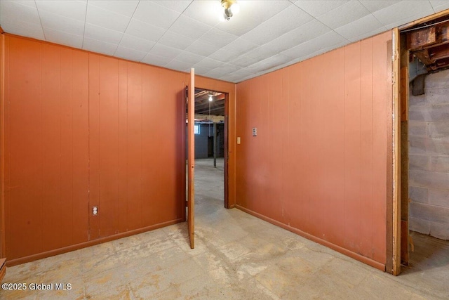 interior space with baseboards and wood walls