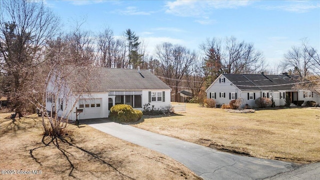 ranch-style house with a front lawn, an attached garage, and driveway