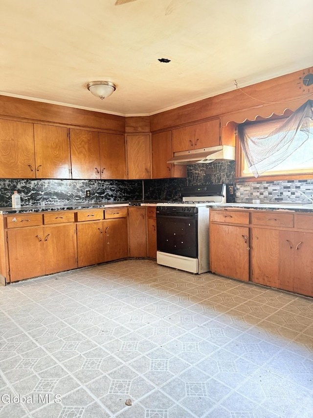 3144 N Thompson St, Rotterdam, NY 12306 - kitchen with gas stove, under cabinet range hood, decorative backsplash, brown cabinets, and dark countertops