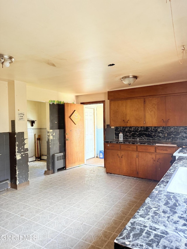 3144 N Thompson St, Rotterdam, NY 12306 - kitchen with brown cabinets, decorative backsplash, and dark countertops