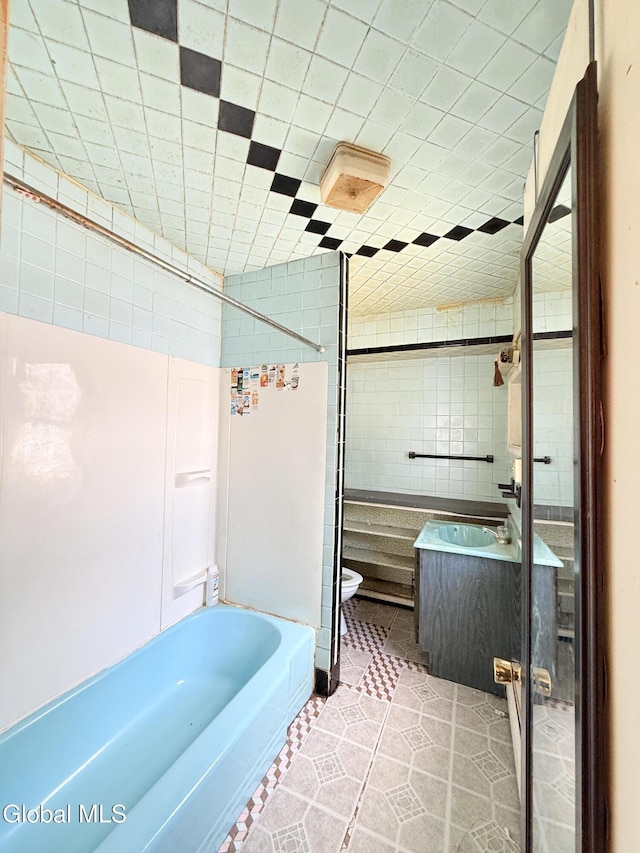 3144 N Thompson St, Rotterdam, NY 12306 - full bathroom featuring tile walls, vanity, tile patterned flooring, and bathing tub / shower combination