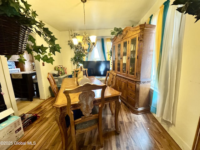 dining area with light wood-style floors and a chandelier