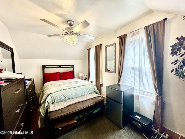 bedroom with ceiling fan, vaulted ceiling, and freestanding refrigerator