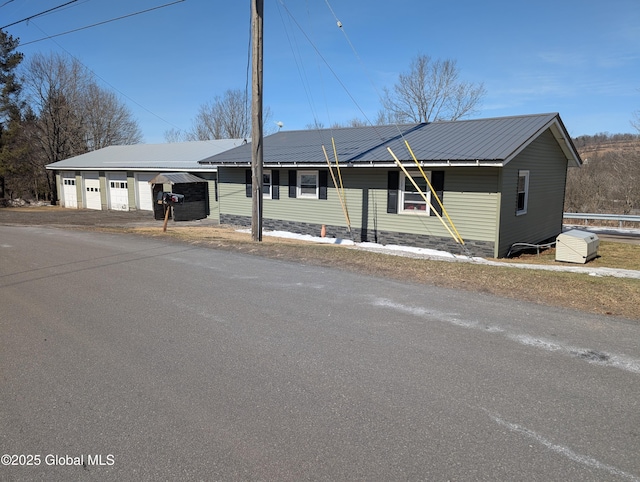 ranch-style house with metal roof and a garage