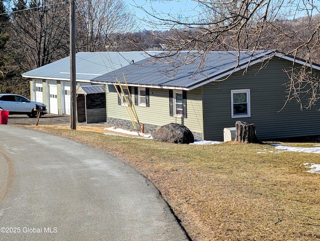 view of front of home with metal roof and a front yard