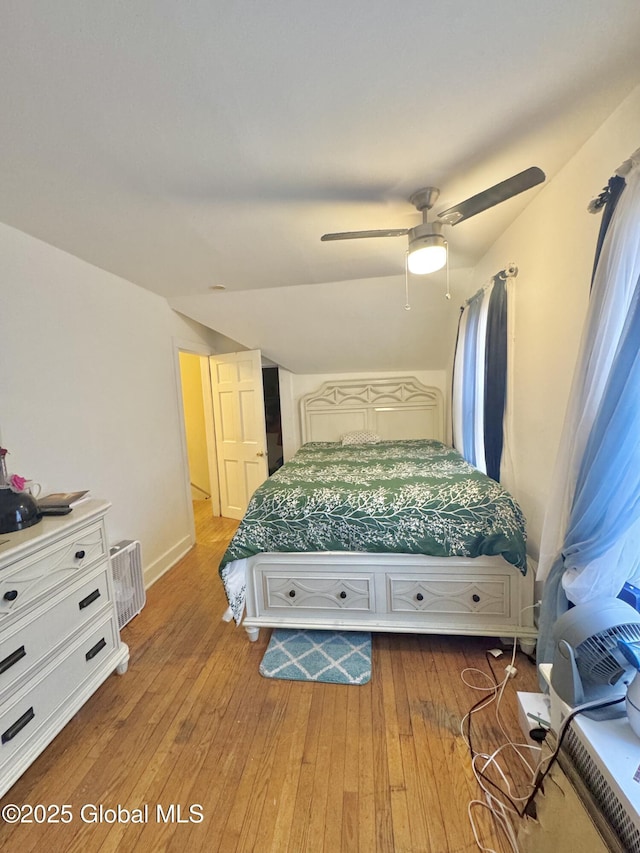 bedroom with light wood-type flooring, ceiling fan, and vaulted ceiling