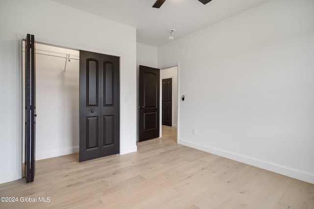 unfurnished bedroom featuring a closet, baseboards, and light wood finished floors