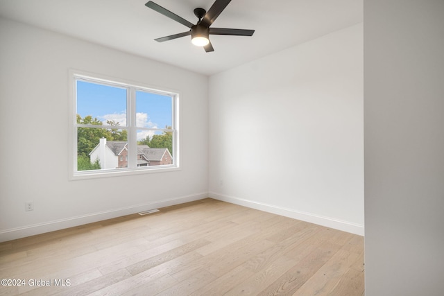 empty room with visible vents, baseboards, light wood-style floors, and a ceiling fan