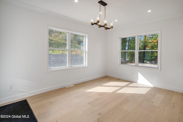 unfurnished room featuring light wood finished floors, baseboards, and ornamental molding