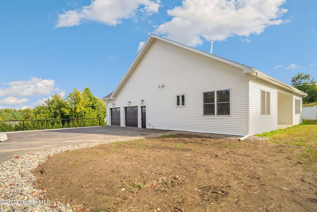 view of property exterior featuring fence and driveway