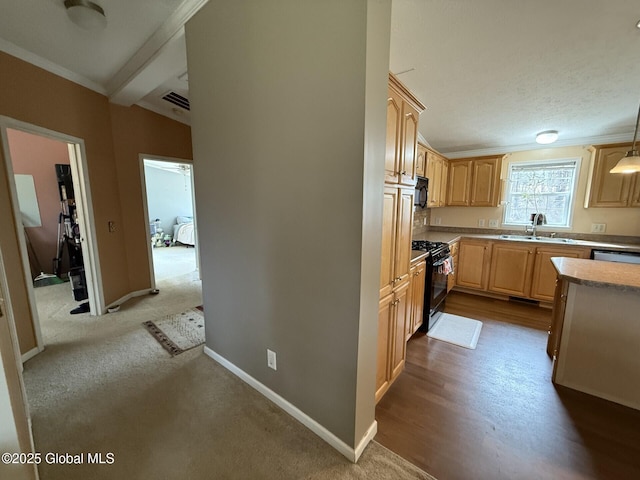 kitchen featuring visible vents, black appliances, ornamental molding, light brown cabinetry, and baseboards