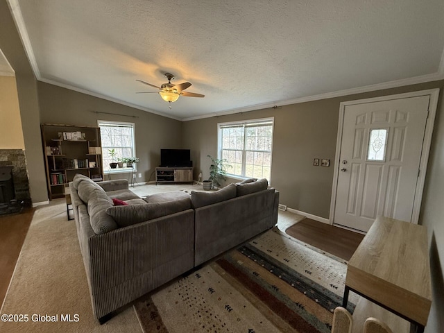 living room with baseboards, ornamental molding, vaulted ceiling, a textured ceiling, and a ceiling fan