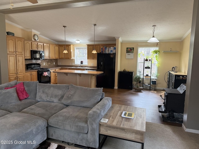 living room featuring dark wood-style floors, vaulted ceiling, baseboards, and ornamental molding