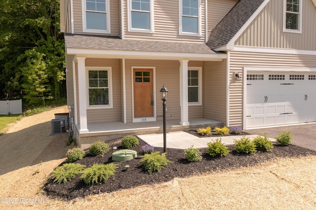 159 Anthony Rd, Halfmoon, NY 12065 - view of front of property with covered porch, a shingled roof, a garage, driveway, and central air condition unit