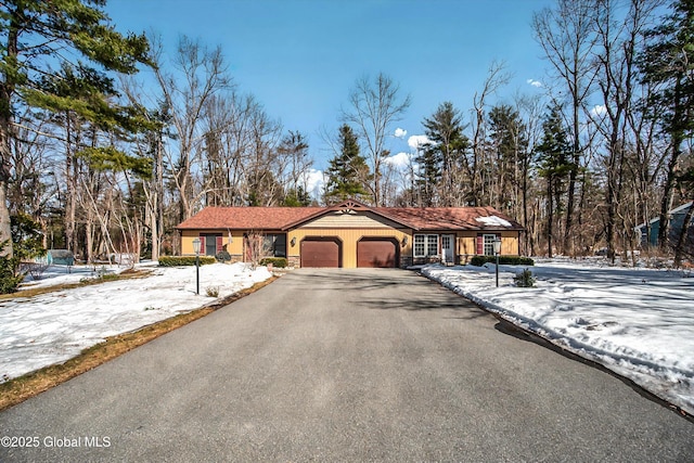 view of front of home with aphalt driveway and an attached garage