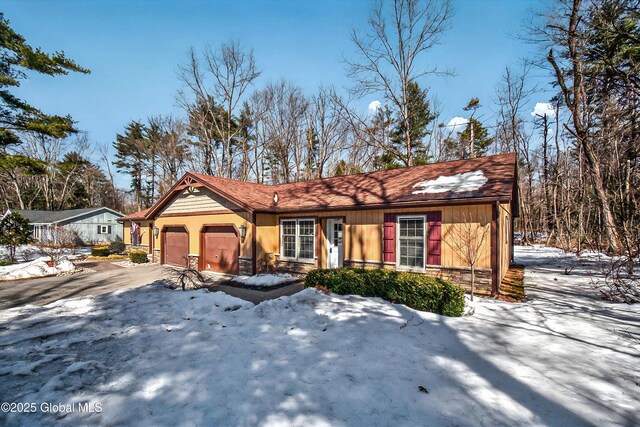 view of front of house with an attached garage and stone siding