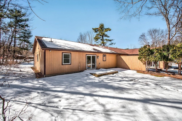 view of snow covered back of property