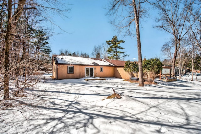 view of snow covered back of property