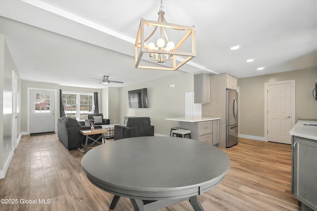 dining room with recessed lighting, light wood-type flooring, baseboards, and ceiling fan with notable chandelier