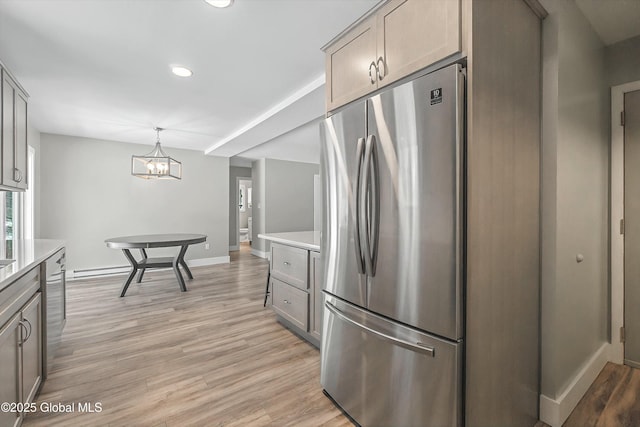 kitchen featuring light countertops, light wood-style floors, baseboards, and freestanding refrigerator