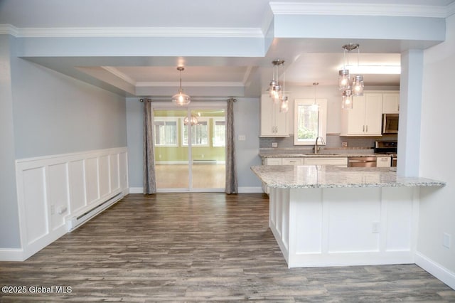 kitchen with a healthy amount of sunlight, a baseboard radiator, appliances with stainless steel finishes, and a sink