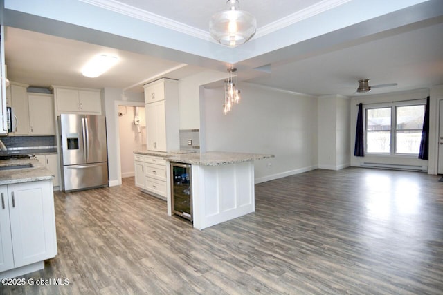 kitchen with backsplash, stainless steel appliances, wine cooler, crown molding, and baseboard heating