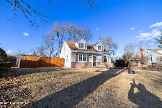 cape cod home featuring fence