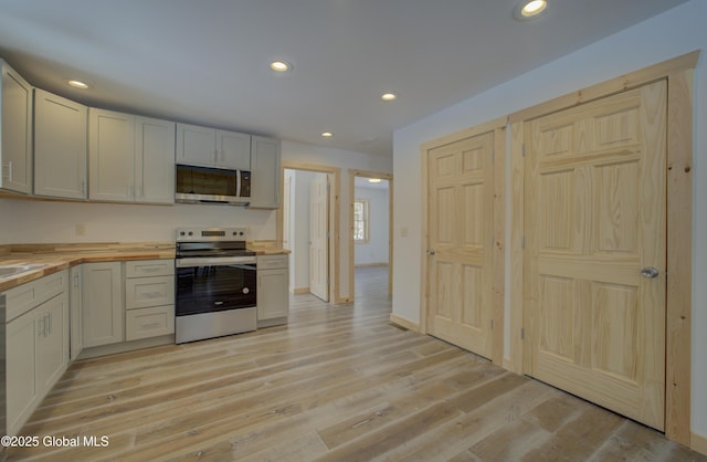 kitchen featuring light wood-style flooring, recessed lighting, appliances with stainless steel finishes, and wood counters