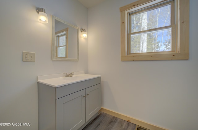 bathroom featuring vanity, wood finished floors, and baseboards