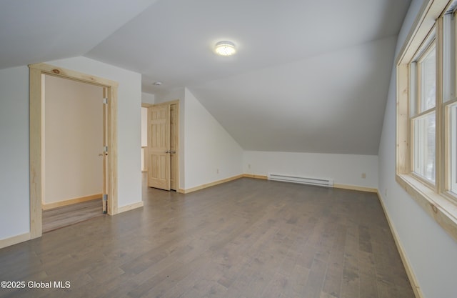 additional living space with baseboard heating, plenty of natural light, lofted ceiling, and wood finished floors