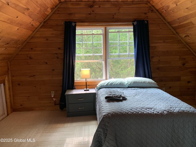 bedroom with wooden walls, multiple windows, and lofted ceiling