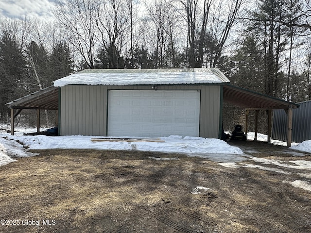 snow covered garage featuring a detached garage