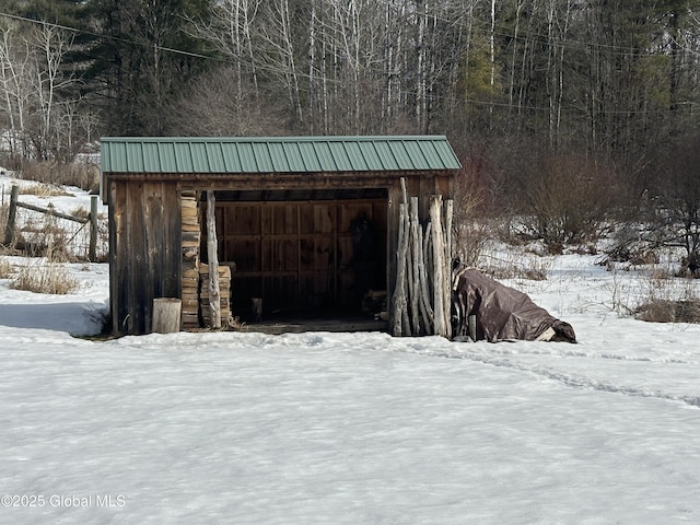 snow covered structure featuring an outdoor structure