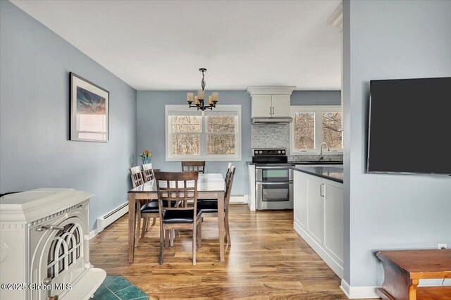1263 Best Rd, East Greenbush, NY 12061 - dining area with wood finished floors, a notable chandelier, baseboards, and baseboard heating