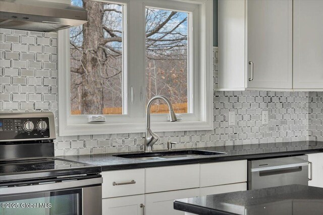 1263 Best Rd, East Greenbush, NY 12061 - kitchen featuring dark countertops, appliances with stainless steel finishes, a sink, wall chimney range hood, and backsplash
