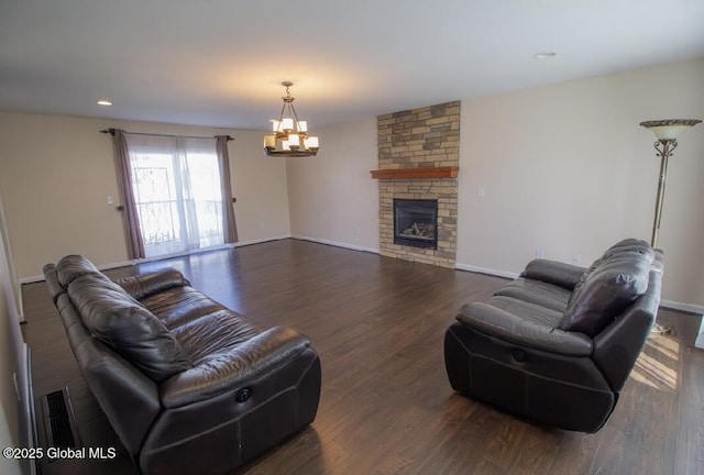 living room with wood finished floors, recessed lighting, a stone fireplace, an inviting chandelier, and baseboards