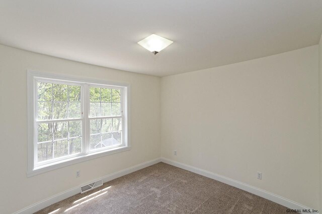 carpeted empty room with visible vents and baseboards