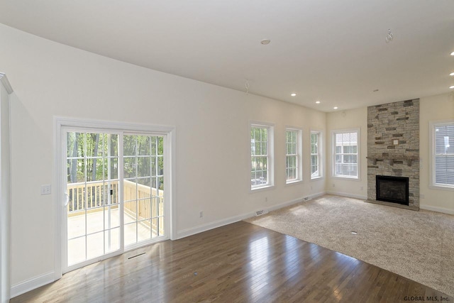 unfurnished living room featuring a wealth of natural light, recessed lighting, baseboards, and wood finished floors