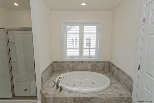 full bathroom with recessed lighting, a tub with jets, and a stall shower