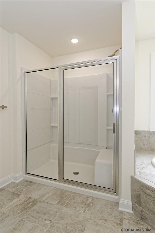 bathroom with a shower stall and a garden tub