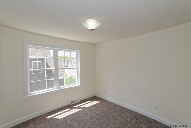 spare room featuring visible vents, baseboards, and carpet floors