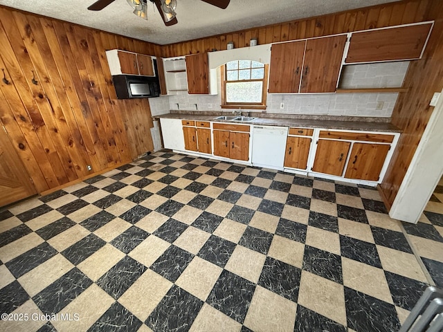 kitchen with a sink, backsplash, dark floors, black microwave, and dishwasher