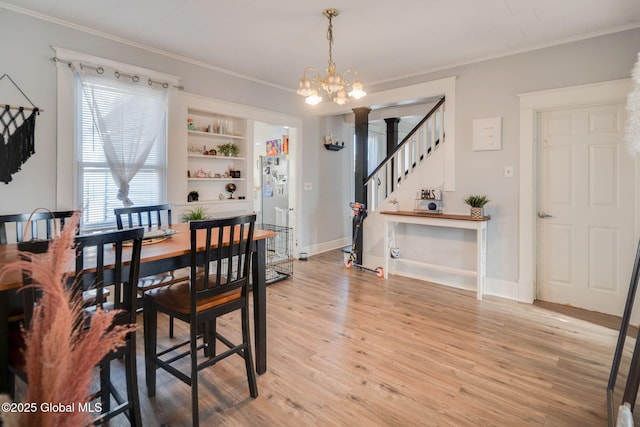 dining room with light wood-type flooring, a chandelier, ornamental molding, and stairway